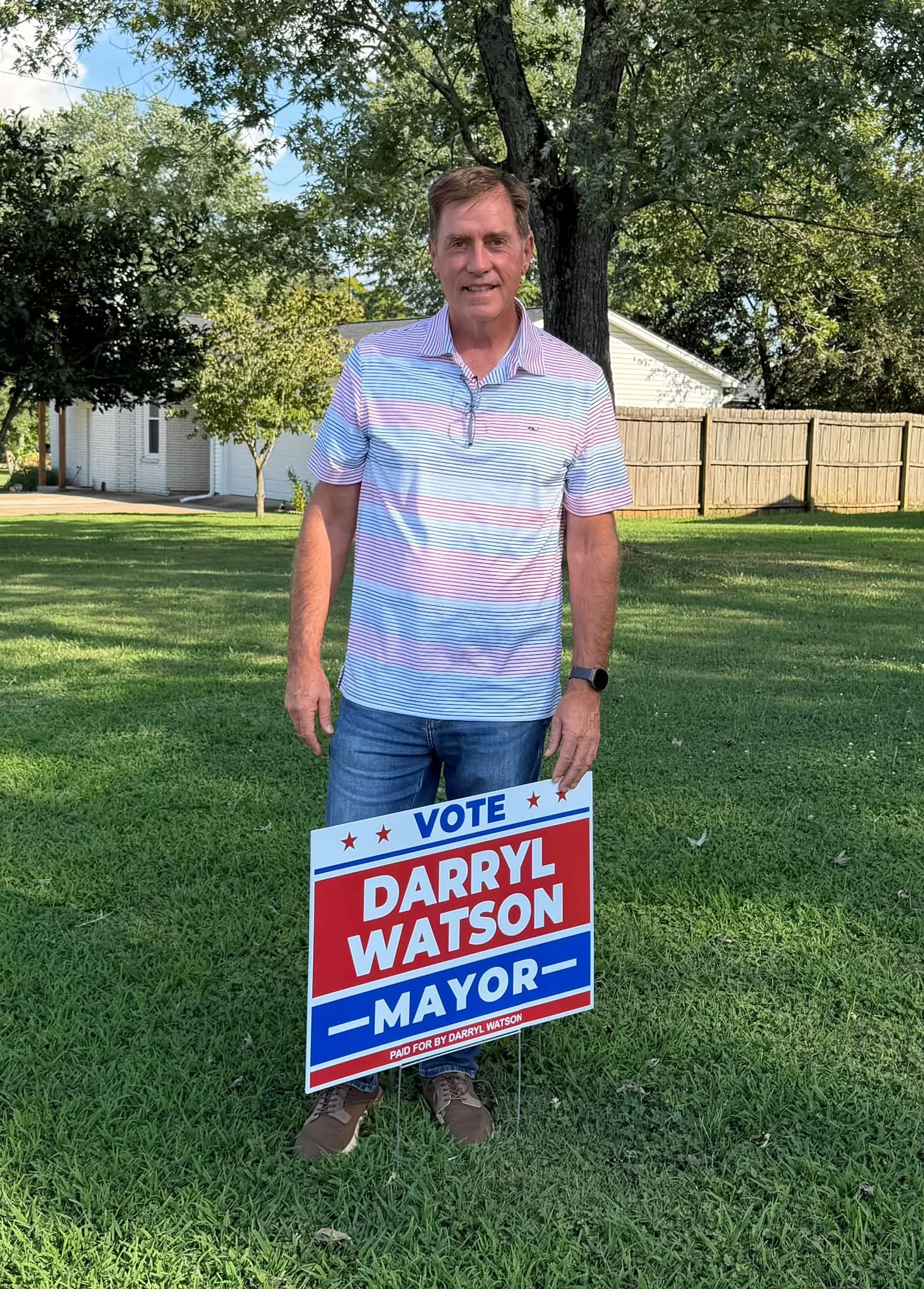 Darryl Watson standing beside a Vote Darryl Watson for Mayor campaign sign